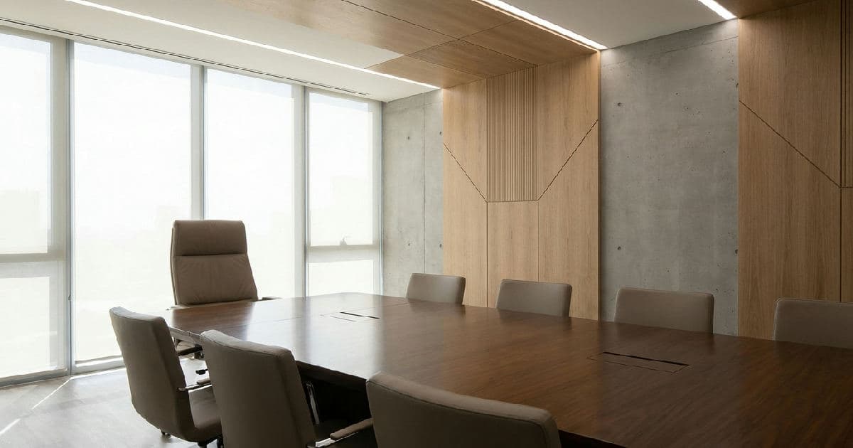 Empty boardroom with modern furnishings and natural lighting, emphasizing leadership transition.