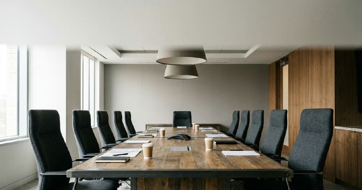 Vacant boardroom with conference table and chairs, professional office environment, no people present.
