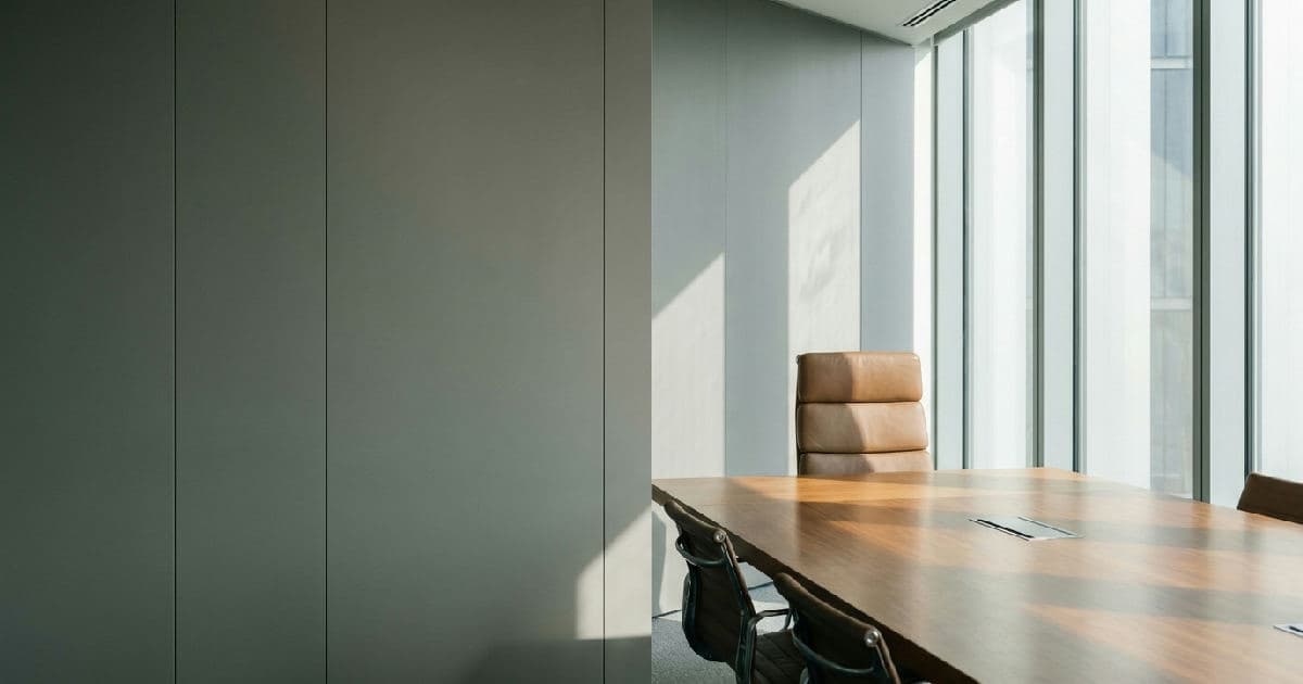 Empty boardroom with polished table and chair, neutral professional setting, no people visible