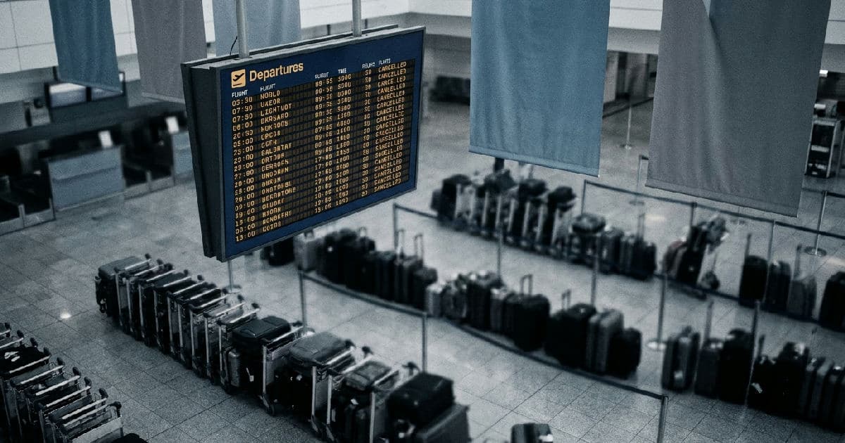Airport departure board showing full flight schedule with queued passenger information displays in muted tones.
