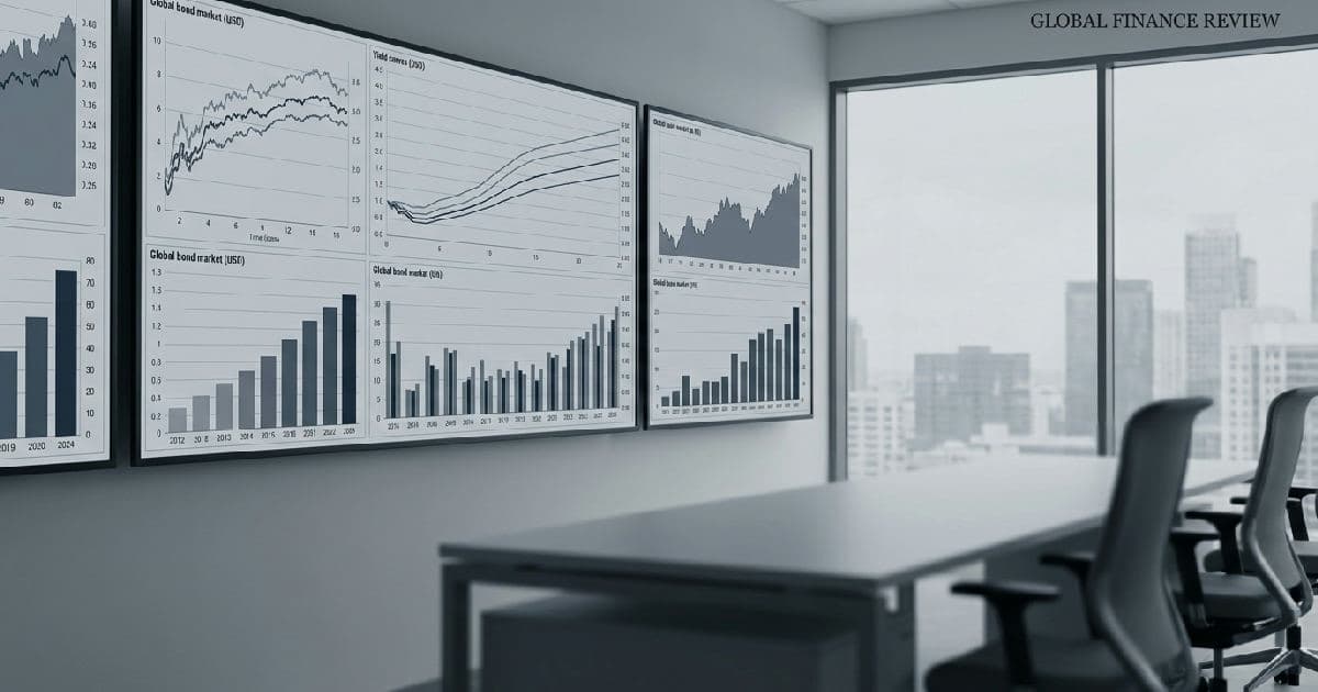 Multiple computer monitors displaying bond yield charts and market data in a desaturated, professional trading environment.