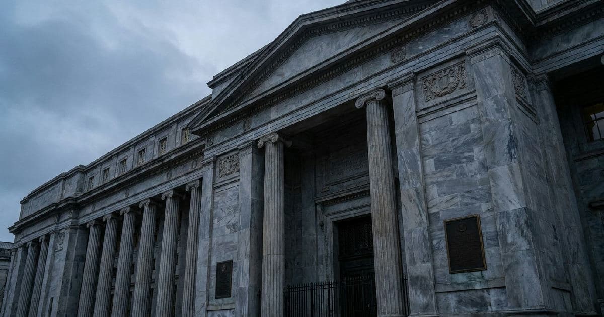 Classical marble columns of a government building beneath an overcast sky.
