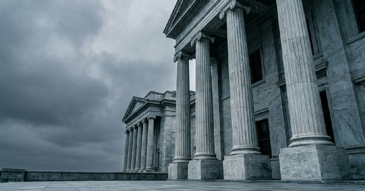 Marble columns of a classical government building beneath an overcast sky.