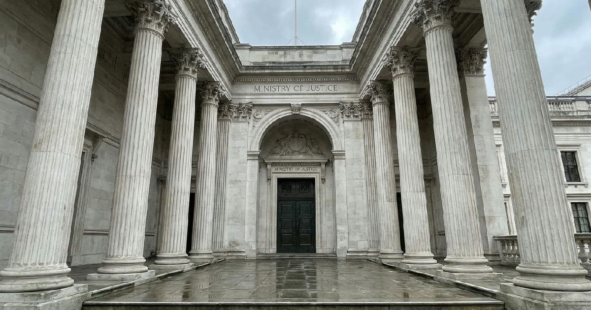 Classical marble columns of a government building under overcast sky, symmetrical architectural composition.