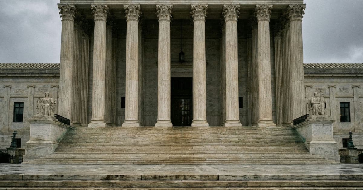 Classical marble courthouse columns and steps under overcast sky, no people.