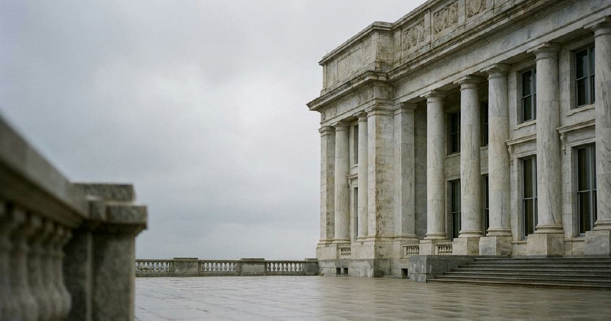 Classical stone columns of a government building facade beneath overcast sky.