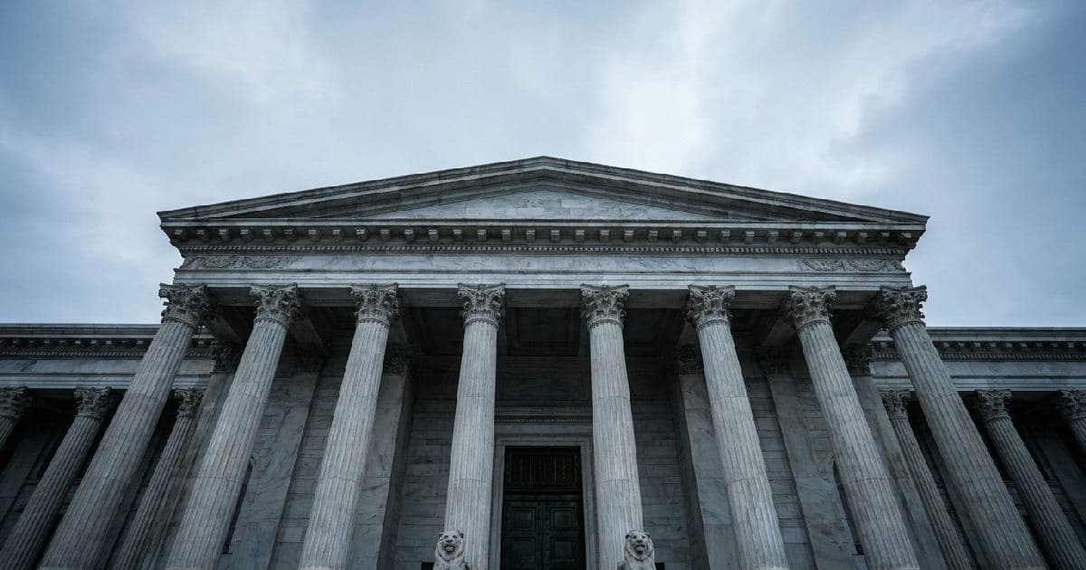 Classical marble columns of a government building under overcast sky, architectural detail shot.