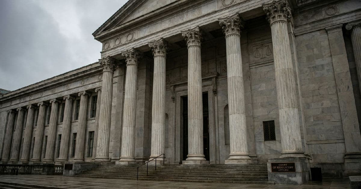 Marble columns of a government building under overcast sky, classical architecture.