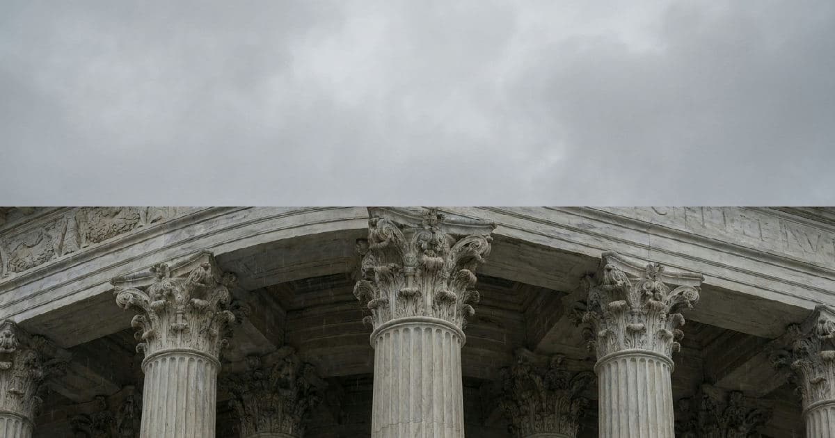 Classical marble columns of a government building under overcast sky, symbolizing regulatory authority.