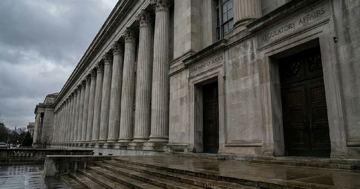 Classical marble columns of a government building beneath overcast sky, empty and austere.