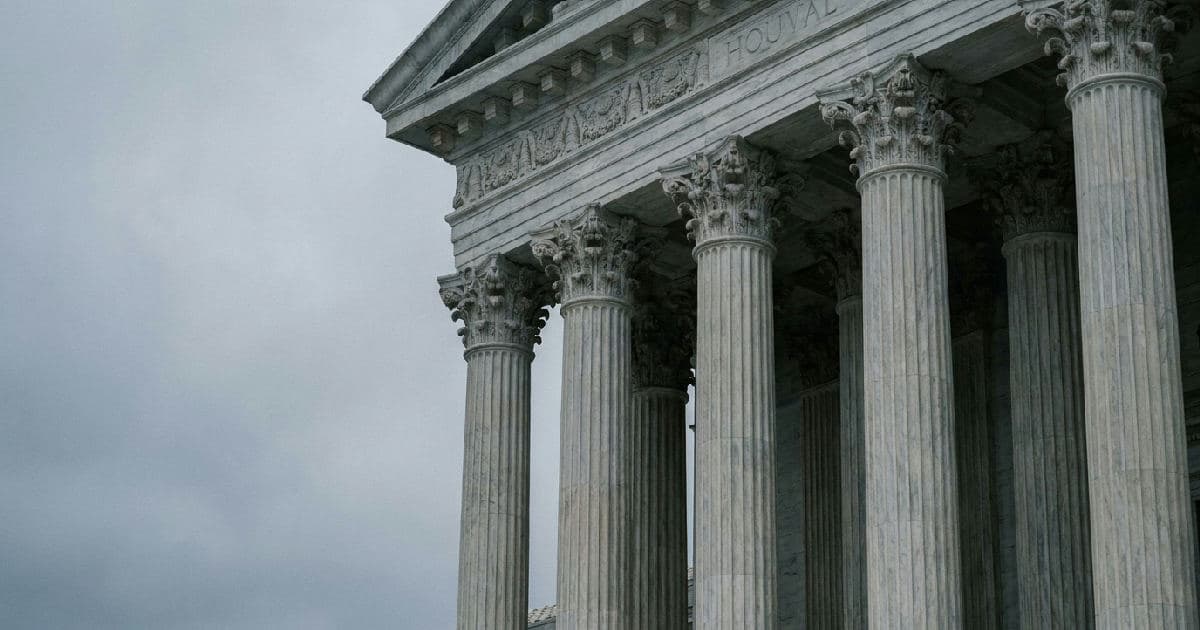Classical marble columns of a government building under overcast sky, no people visible.