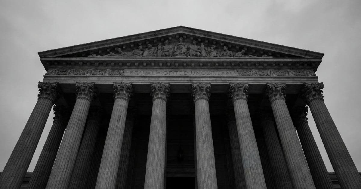 Neoclassical marble columns of a government building facade under overcast sky
