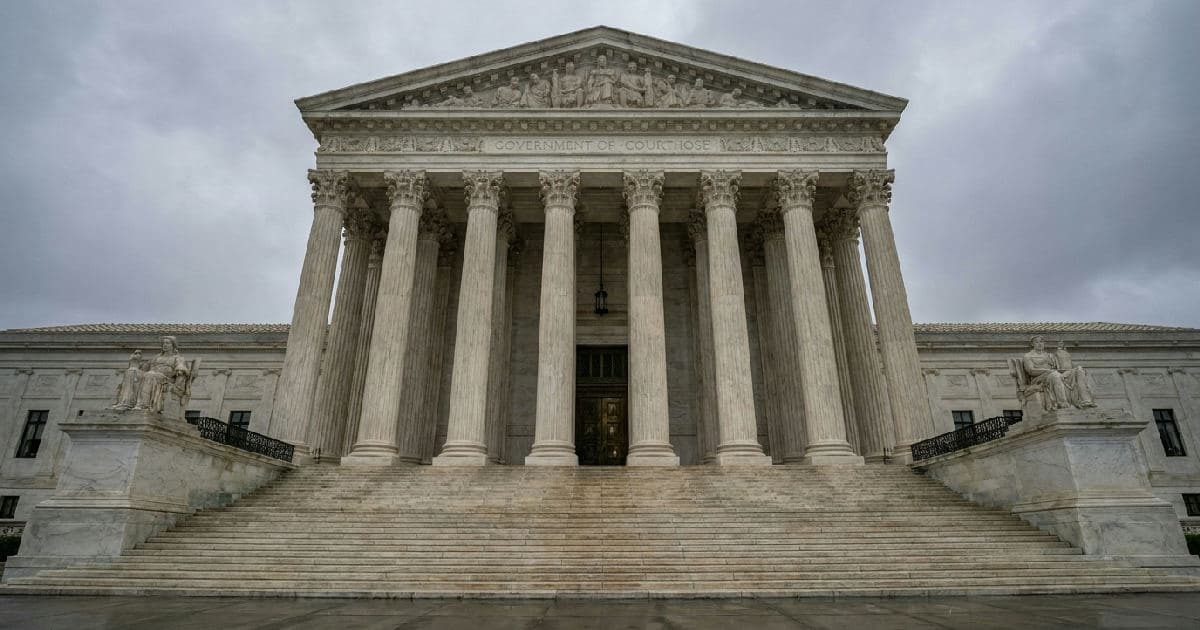 Classical marble columns and courthouse steps under overcast sky, architectural symbol of legal proceedings.