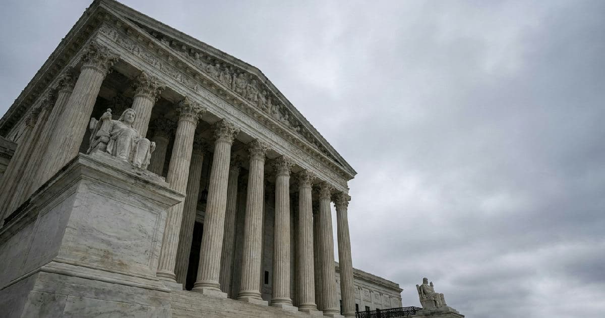 Classical marble columns of a government building under overcast sky, no people.