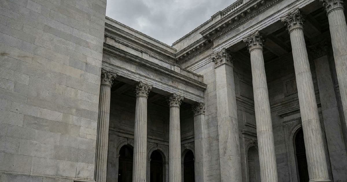 Classical stone columns and government building exterior beneath overcast sky, no people.