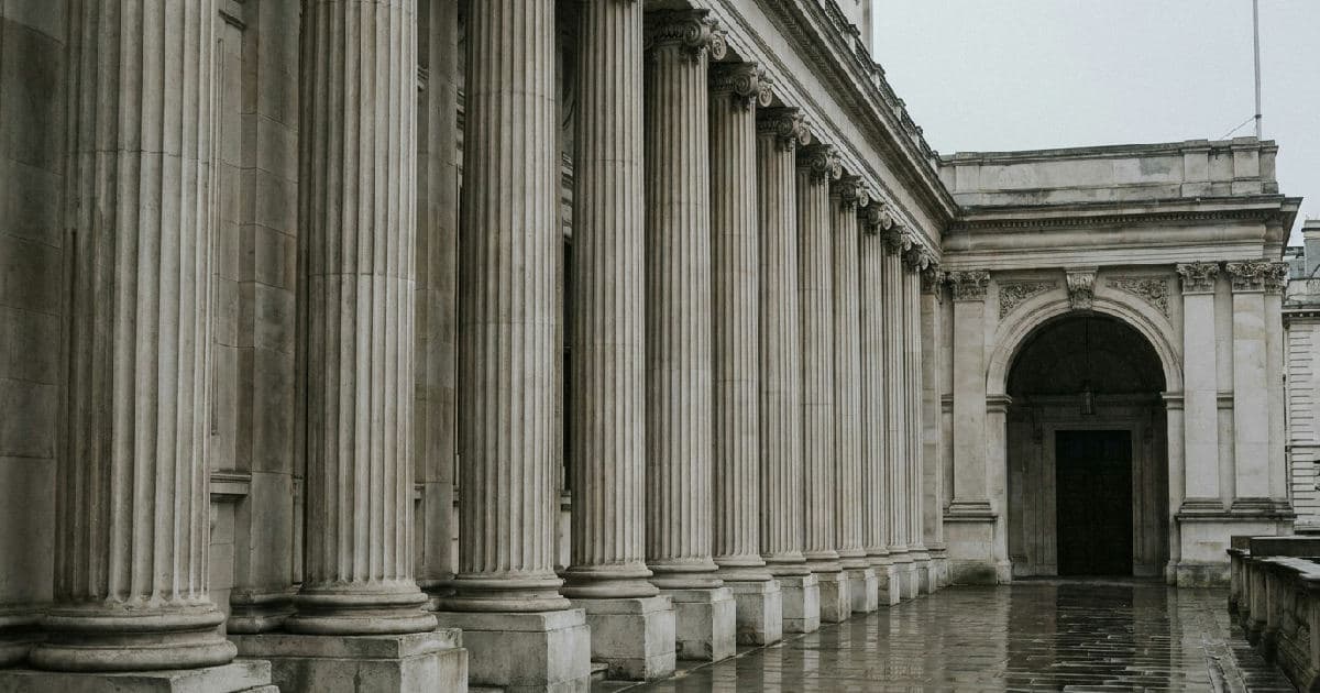 Classical marble columns of a government building under overcast sky, formal architectural composition.