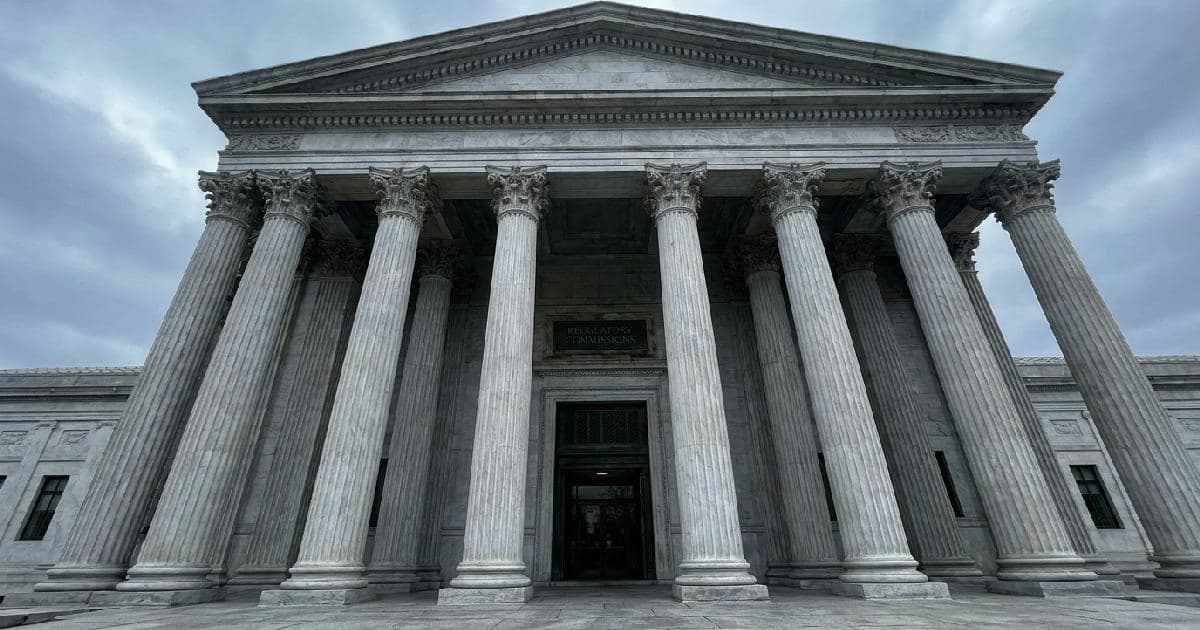 Classical marble columns of a government building beneath an overcast sky.