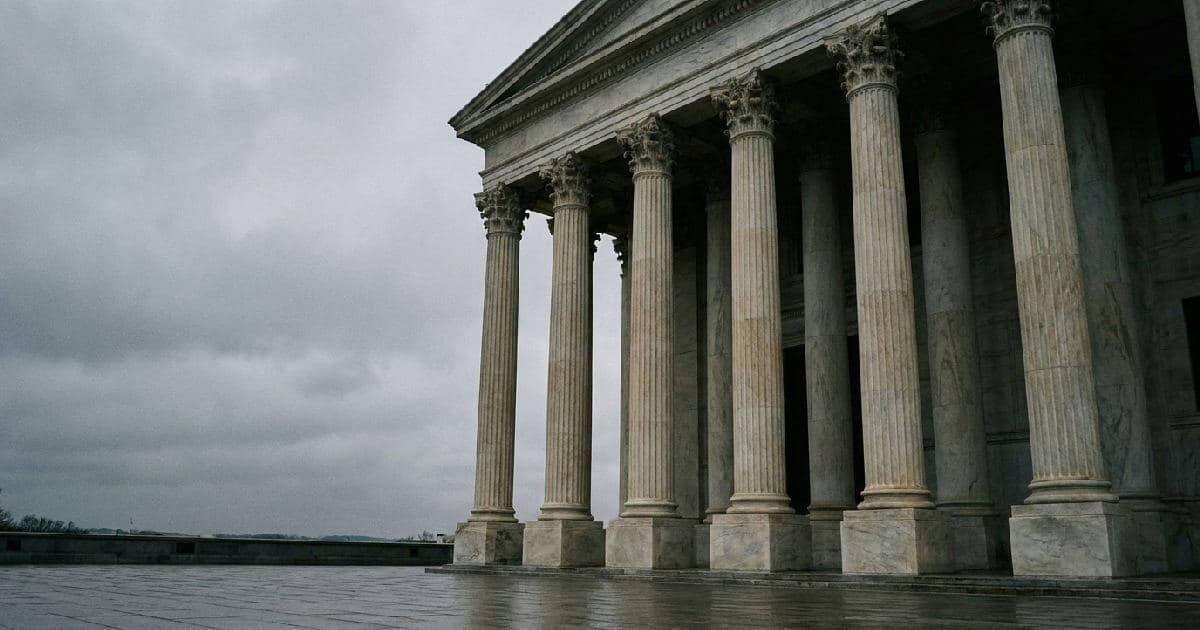 Classical marble columns of a government building facade under overcast sky, no people visible.