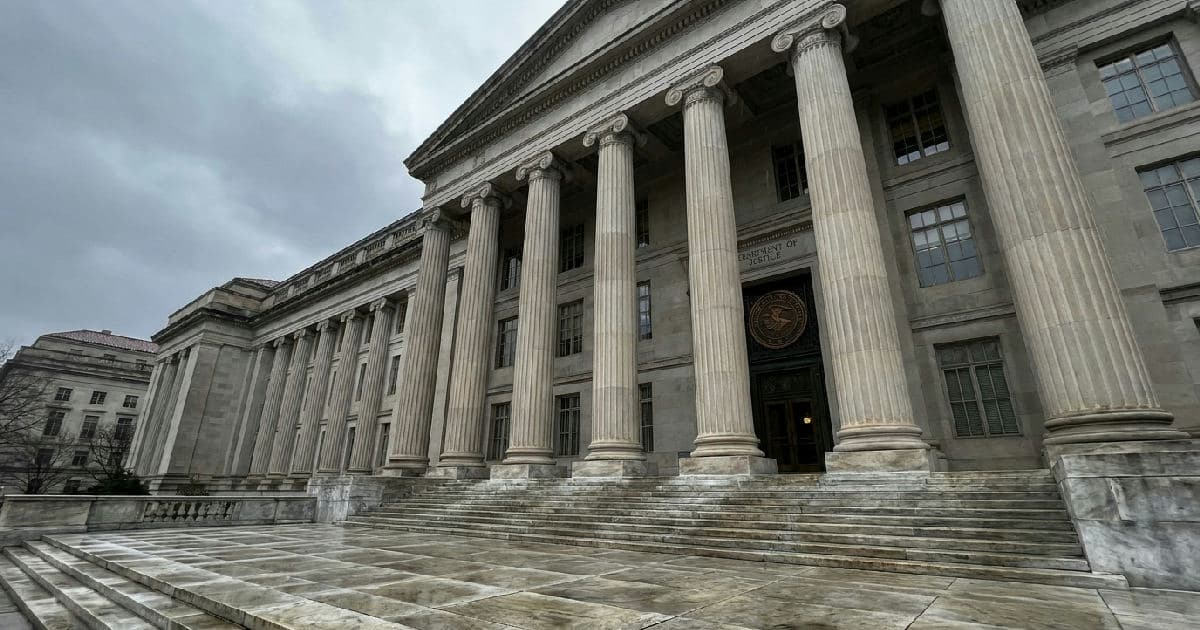 Classical marble columns of a government building beneath an overcast sky, empty and austere.