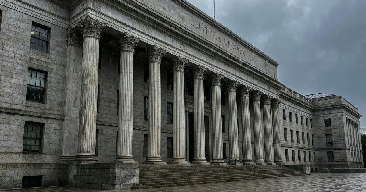 Classical marble columns of a government building beneath overcast sky, symbolizing regulatory authority.
