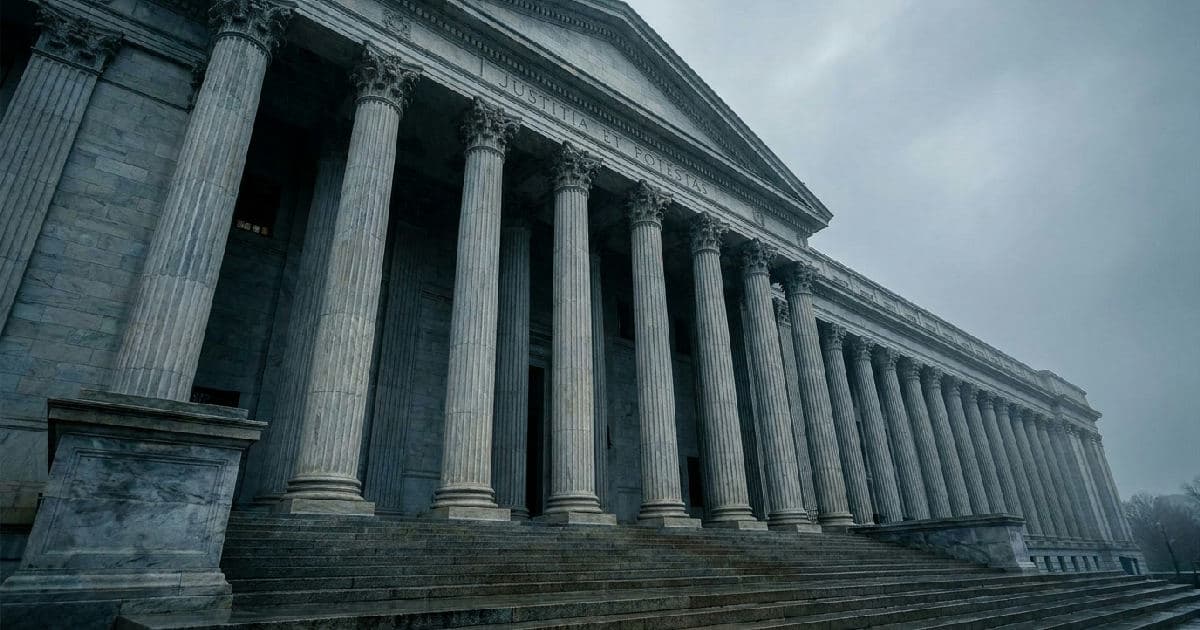 Classical marble columns of a government building beneath an overcast sky.
